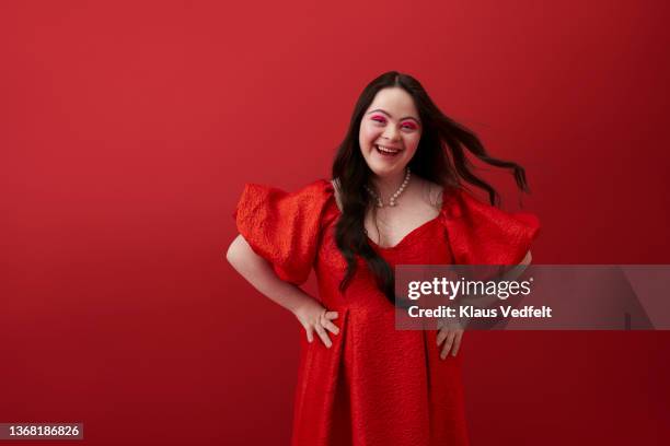 young woman with hand on hip against red background - cut out dress stock pictures, royalty-free photos & images