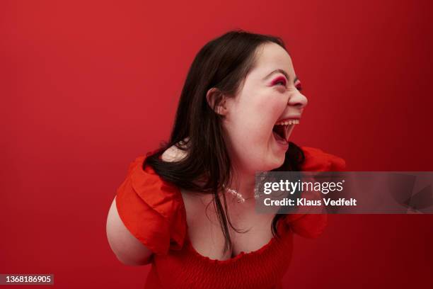 happy woman laughing against red background - portrait femme fond rouge adulte photos et images de collection