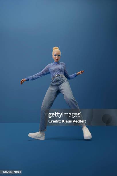 albino woman dancing against blue background - dancer fotografías e imágenes de stock