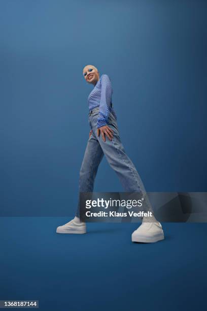 smiling albino woman against blue background - full length portrait woman stock pictures, royalty-free photos & images