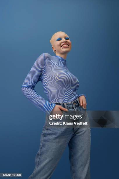 happy albino woman standing with hands in pockets - albino stock-fotos und bilder