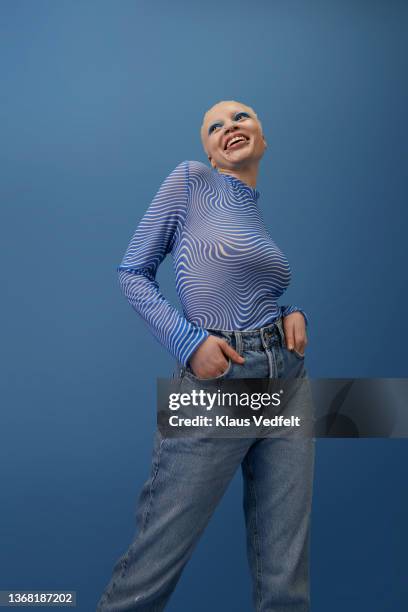 albino woman standing with hands in pockets looking away - hände in den taschen stock-fotos und bilder