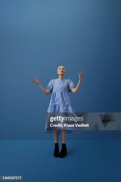 albino woman gesturing against blue background - blue dress stock pictures, royalty-free photos & images