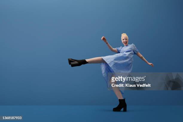 albino woman shouting while kicking leg - ganzkörperansicht stock-fotos und bilder