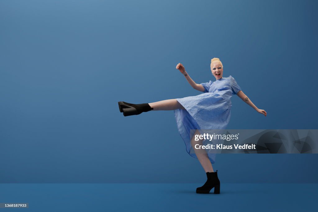 Albino woman shouting while kicking leg