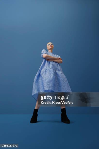 confident albino woman standing with arms crossed - botas azules fotografías e imágenes de stock
