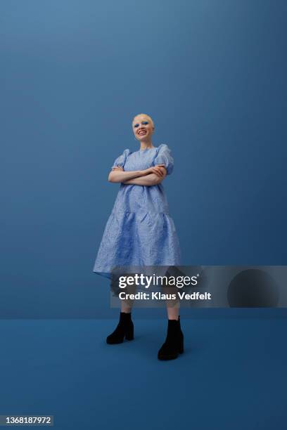 smiling albino woman standing with arms crossed - vrouw staat in mooie jurk stockfoto's en -beelden