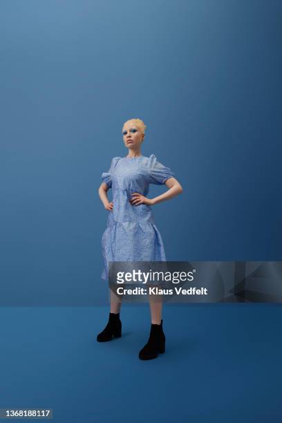 albino woman standing with hand on hip - botas azules fotografías e imágenes de stock
