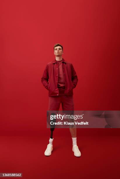 young man standing with hands in pockets - red shorts stock pictures, royalty-free photos & images