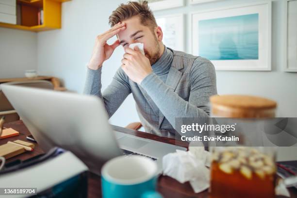 ill young man is sneezing - allergy doctor stockfoto's en -beelden