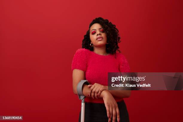 curly haired with crutch against red background - schwarzes haar stock-fotos und bilder