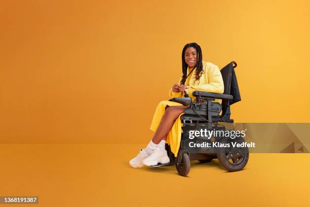 smiling woman with disability in wheelchair - chaise roulante photos et images de collection