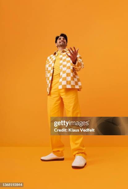 smiling man with vitiligo gesturing against yellow background - asiatischer mann freigestellt stock-fotos und bilder