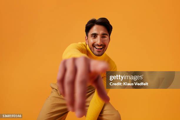 happy man with vitiligo pointing against yellow background - point fotografías e imágenes de stock