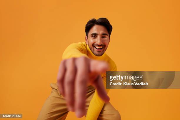 happy man with vitiligo pointing against yellow background - one finger stockfoto's en -beelden