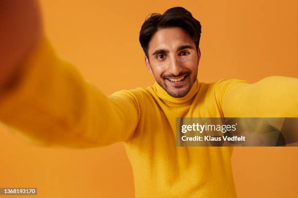 happy man with vitiligo taking selfie against yellow background - cuello alto fotografías e imágenes de stock