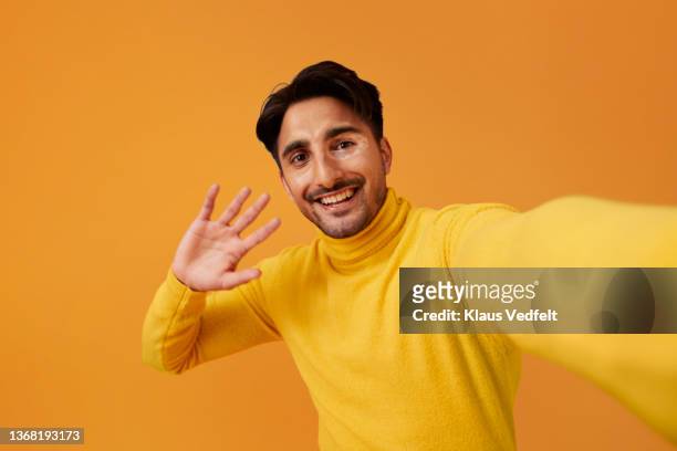 happy man with vitiligo waving hand against yellow background - waving imagens e fotografias de stock