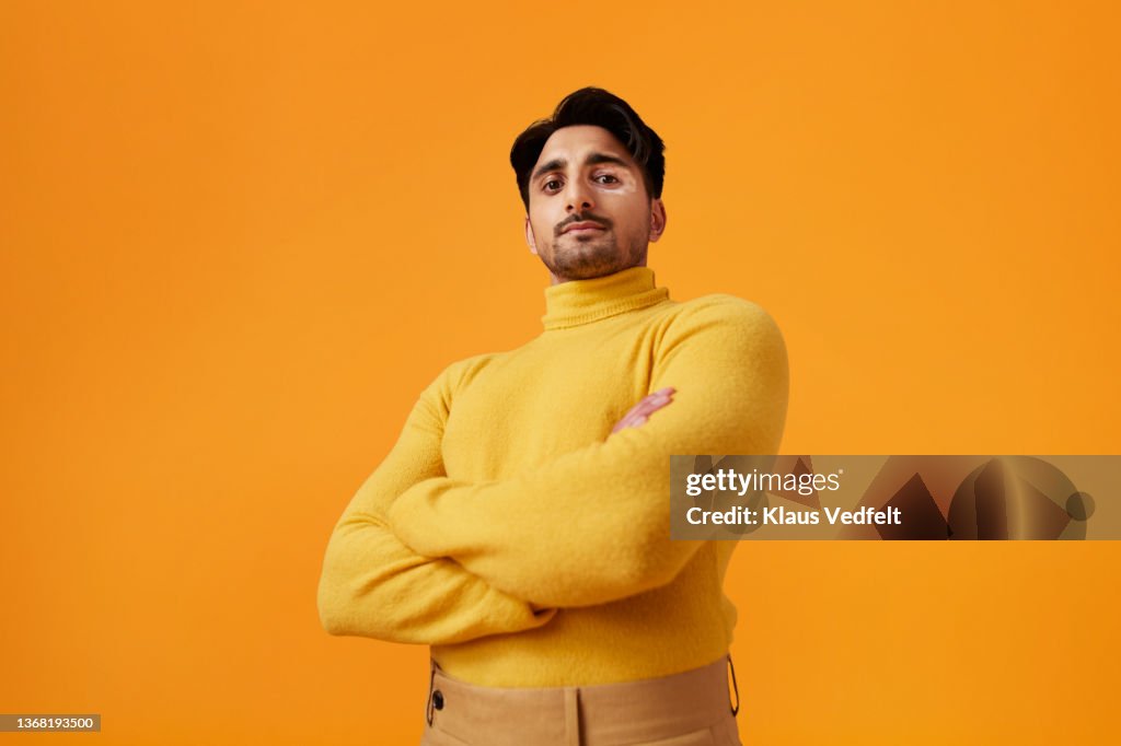 Confident man with vitiligo standing with arms crossed