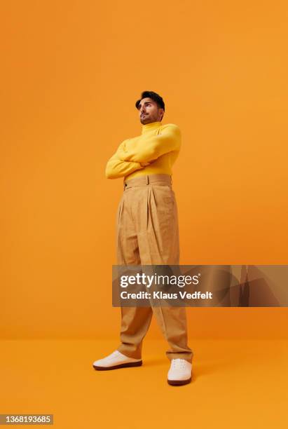 man with vitiligo standing with arms crossed - vista de ángulo bajo fotografías e imágenes de stock