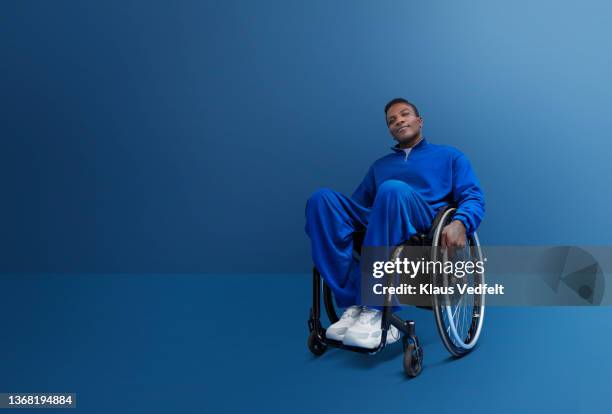 confident disabled man sitting in wheelchair - wheelchair stockfoto's en -beelden