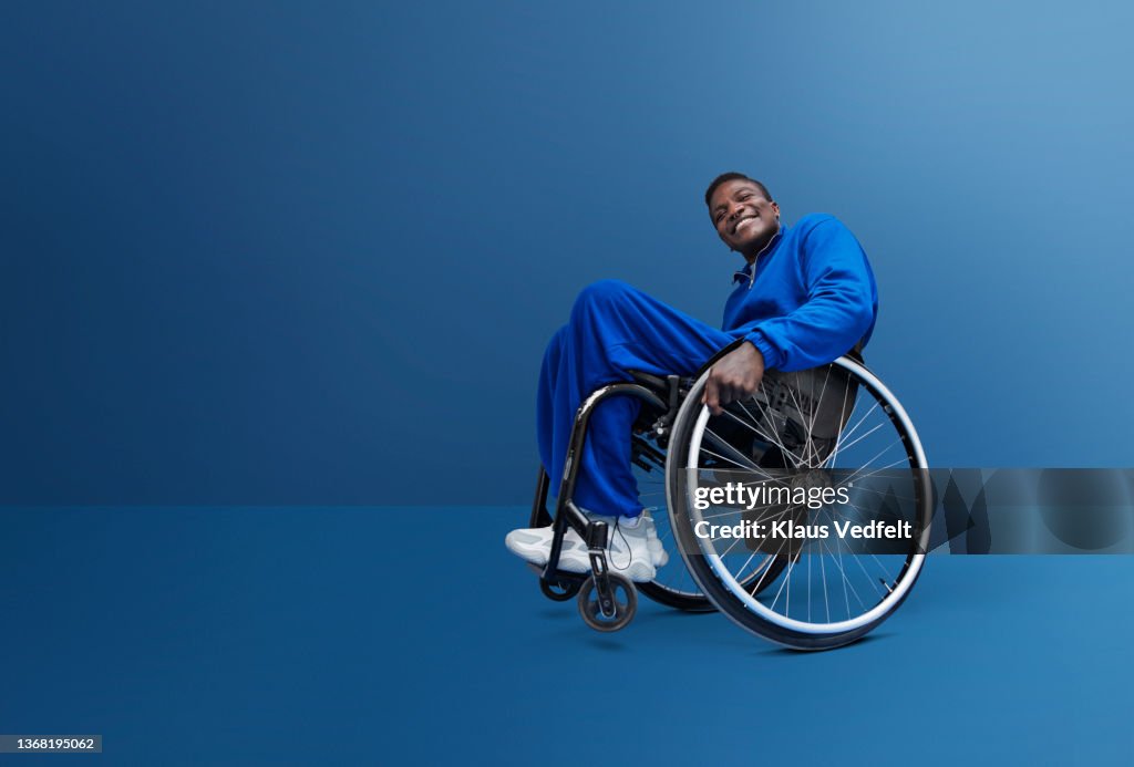Man with disability in tracksuit sitting in wheelchair