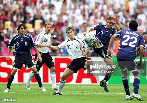 Gabriel Heinze of Argentina clears in front of Miroslav Klose of Germany during their quarterfinal match at the Olympiastadion in Berlin, Germany on...