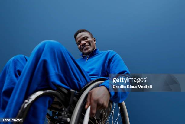 Smiling young man with disability sitting in wheelchair