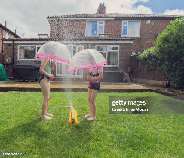 playing in sprinkler - sprinkler stock pictures, royalty-free photos & images