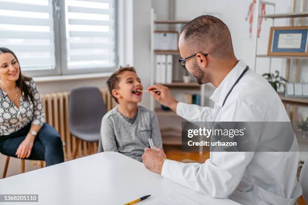 pediatrician taking a throat swab from the child patient - test strip stock pictures, royalty-free photos & images