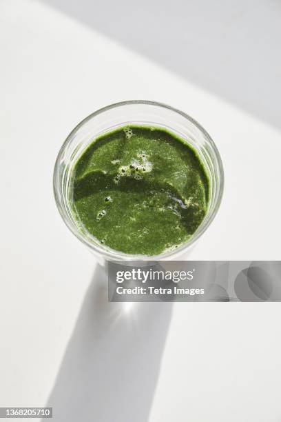 overhead view of glass of green smoothie - blended drink ストックフォトと画像