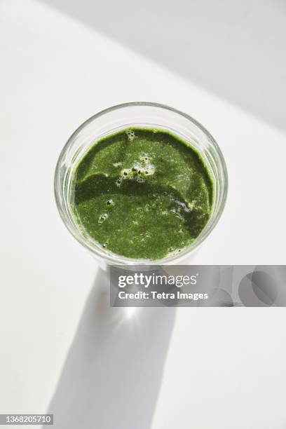 overhead view of glass of green smoothie - blended drink stock pictures, royalty-free photos & images