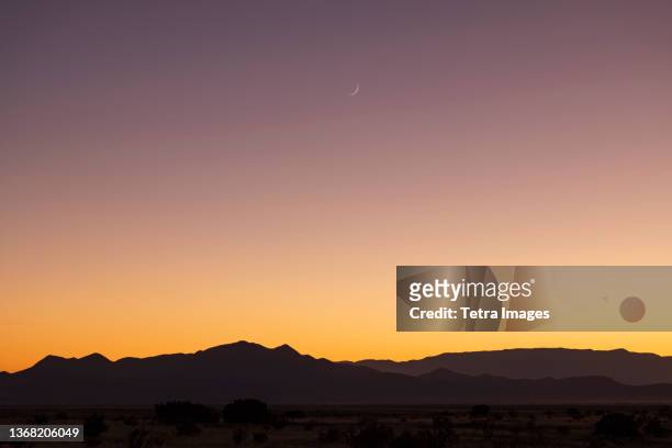 usa, new mexico, santa fe, crescent moon above jemez mountains at sunset - new mexico fotografías e imágenes de stock