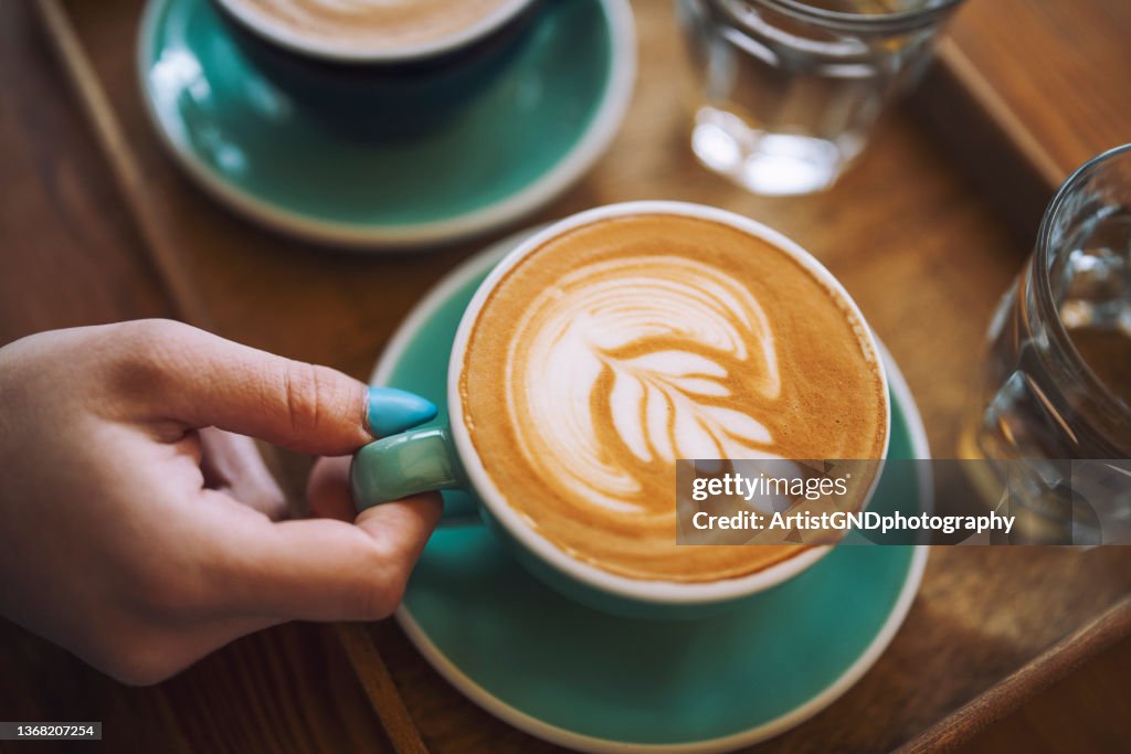 Frau mit einer Tasse Café Latte im Café.
