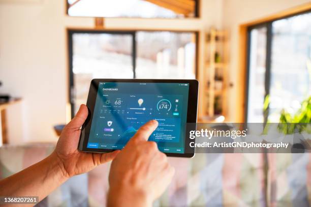 hombre usando tableta con funciones de control inteligente del hogar en casa. - connected home fotografías e imágenes de stock