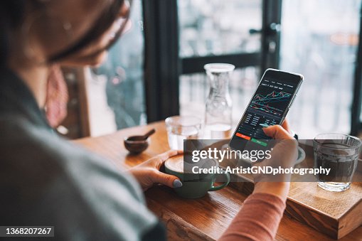 Woman using smartphone buy cryptocurrency at a coffee shop, blockchain investment, decentralize and Stock market concept. Woman using smartphone buy cryptocurrency at a coffee shop, blockchain investment, decentralize and Stock market concept.