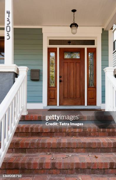 front door of suburban home - tetra images stock-fotos und bilder