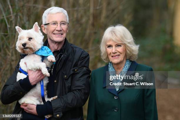 Camilla, Duchess of Cornwall, patron of Battersea Dogs and Cats Home and Battersea Ambassador Paul O’Grady on a brief woodland walk with a rescue dog...