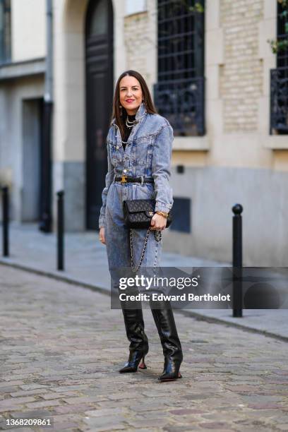 Alba Garavito Torre wears a black turtleneck pullover, gold and pearls large pendant earrings, white pearls necklaces, a blue faded denim buttoned...