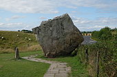 giant square rock in a meadow with sheep