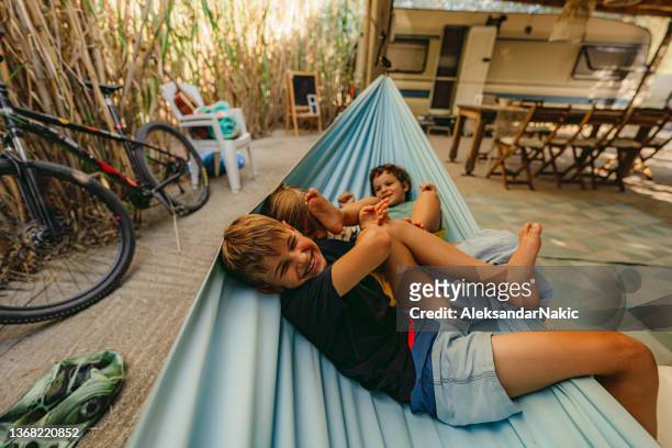 relaxing moments in a hammock - family caravan stockfoto's en -beelden