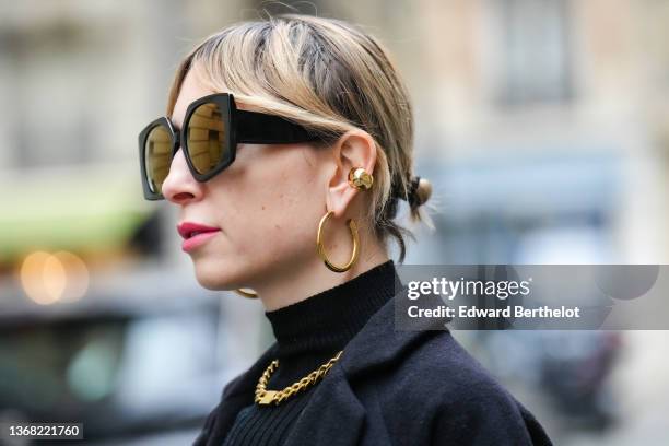 Emy Venturini wears black sunglasses, gold earrings from Merbabegr, gold large chain necklace and bracelet from Merbabegr, a black long vintage...