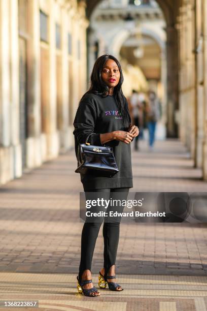Carrole Sagba @linaose wears a black with neon green / blue / pink embroidered inscriptions sweater from Sonia Rykiel, a black shiny leather vintage...