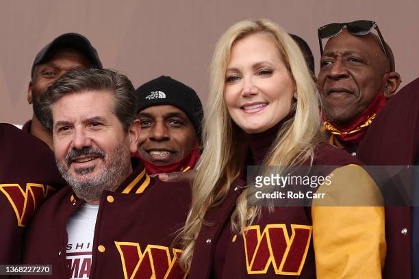 Team co-owners Dan and Tanya Snyder pose for a photo with former team members during the announcement of the Washington Football Team's name change...