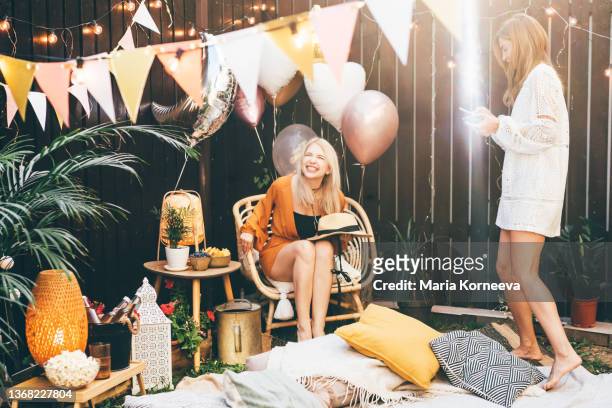 cheerful girl friends hanging out at backyard party. - garden party stock-fotos und bilder