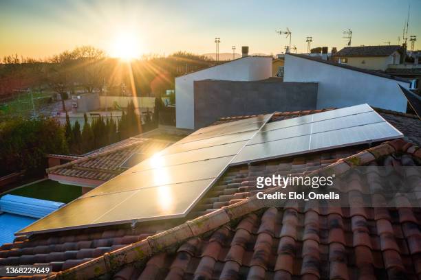 sonnenkollektoren auf einem dach - solar panel city stock-fotos und bilder