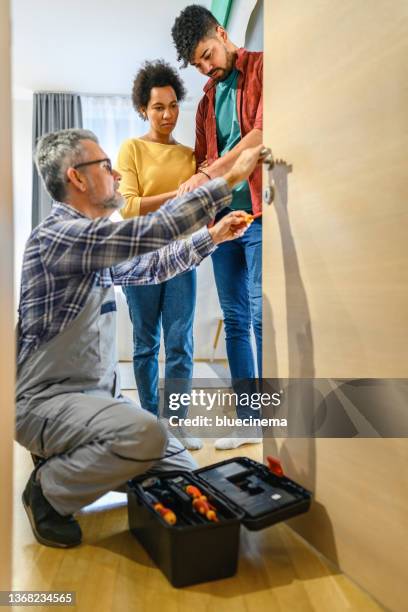 locksmith working with house door lock using a screwdriver - serralheiro imagens e fotografias de stock