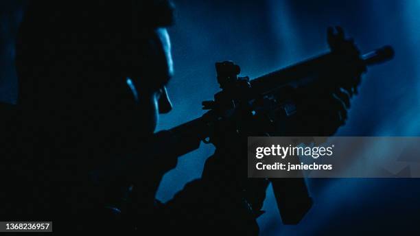 sniper's training on a shooting range. m4 ar-15 rifle details. looking over the shoulder, blue illuminations - gunman stock pictures, royalty-free photos & images