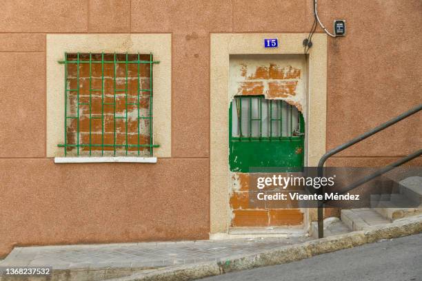 house boarded up and later occupied - security bar door stock pictures, royalty-free photos & images
