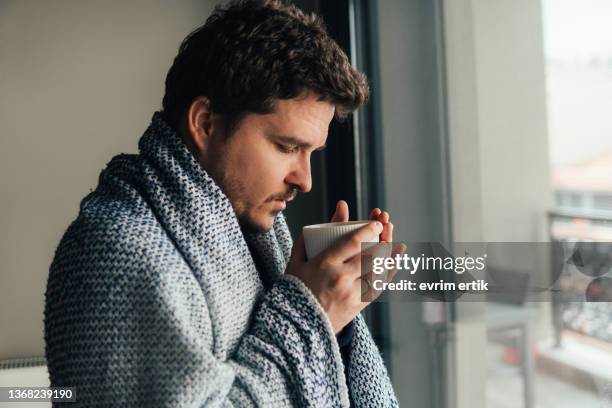 man with blanket drinking coffee on cold winter morning - thermometer turkey stock pictures, royalty-free photos & images