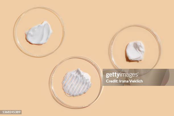 smears of beauty product white gel and cosmetic cream in petri dish on pastel beige color background. - cream colored 個照片及圖片檔